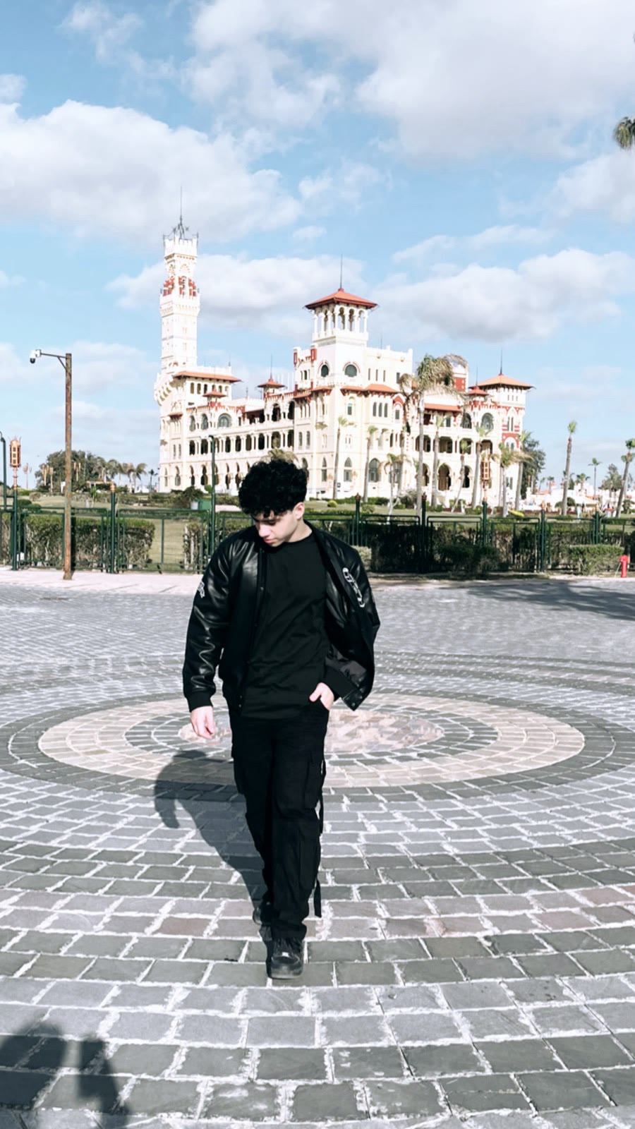 Ziad walking across a square in front of a historic palace